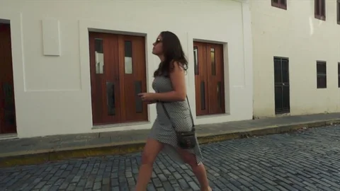 Slow motion of tourist walking on cobblestone street, taking photo on her phone Stock Footage 81672406