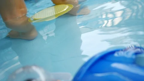 Slow motion toy floating on clean water of baby swimming pool Stock Footage 93103642