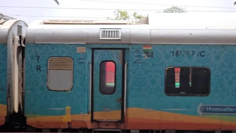 Slow motion tracking perspective past a blue AC Three Tier Humsafar Express coac Vídeo Stock 341349117