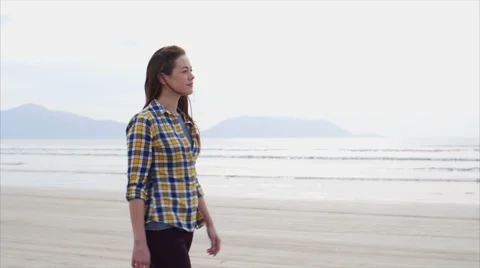 Slow motion tracking shot of attractive woman walking on beach Stock Footage 59076028