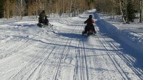 Slow motion tracking shot as camera follows parents riding motor sledge Stock Footage 110905219