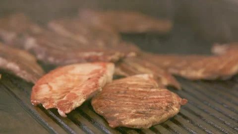 Slow Motion Tracking Shot of Chicken Sizzling on Flat Top Grill Stock Footage 301076614