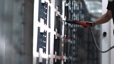Slow motion tracking shot of an industrial emplyee, painting a metal sheet Stock Footage 247316046