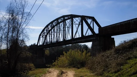 Slow-motion tracking shot of old railway bridge over river Stock Footage 122656343