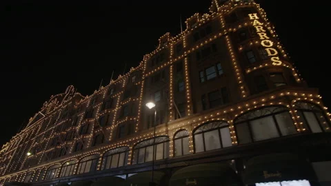 Slow motion tracking shot past Harrods at night in the West End of London Vídeos de archivo 168015524