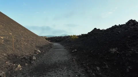 Slow motion tracking shot of volcanic path, Caldera de Los Cuervos, Lanzarote Stock Footage 346376901