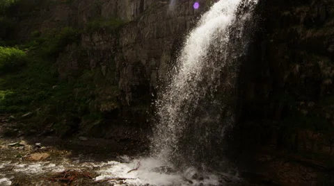 Slow motion tracking shot of waterfall with sun flare Stock Footage 52498604