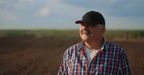Slow motion A tractor driver looks at the work done at sunset Stock Footage 131929111