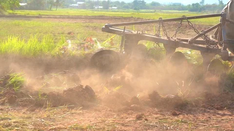 Slow motion tractor plowing soil grass filed farm agriculture for planting tree Stock Footage 106663078
