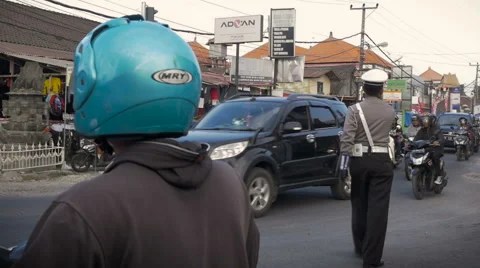 Slow motion of a traffic cop directing scooter traffic in Bali Video stock 55471671