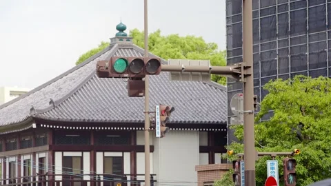 Slow motion of traffic light turning from red to green beside traditional houses Stock Footage 328414336