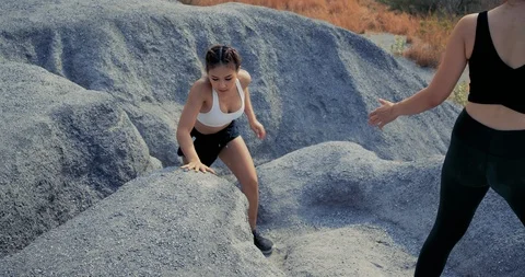 SLOW MOTION, Trail Running partners helping in the rock mountain climb up Stockbeeldmateriaal 124411763