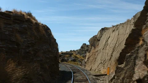 Slow motion train tracks moving through rocky cliffs Vídeos de archivo 88381753