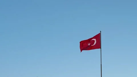 Slow motion of Turkish flag developing on the background of cloudless blue sky Video stock 221226755