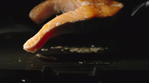 SLOW MOTION: Turning A Trout Fish Slice On A Black Grill While Cooking 動画素材 117649013