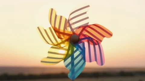 Slow motion the turns color plastic pinwheel, windmill with blowing sunset Stock-Footage 114061768