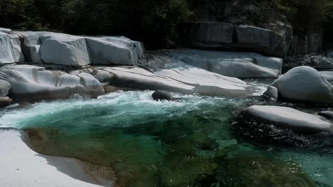 Slow motion of turquoise mountain river pool between large boulders Stock Footage 346184679