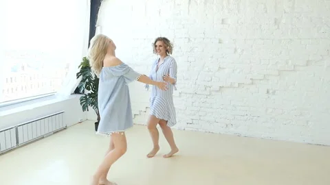 Slow motion, two blonde sisters dancing holding the hands Stock-Footage 88960744