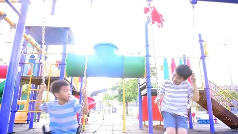 Slow motion two boy play swing outdoor Stock Footage 79588762