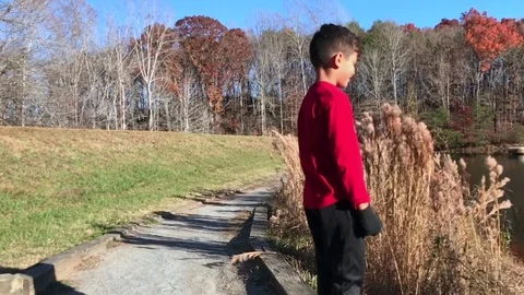 Slow motion of two brothers playing by a lake on a beautiful day Stock Footage 83097161