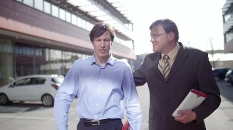 Slow motion of two business men walk and talk friendly Stock Footage 49740071