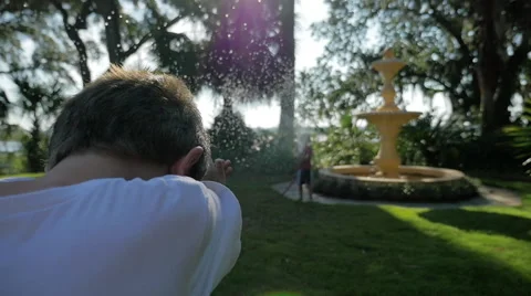 Slow motion, two children having a water fight. Shallow Depth of field Stock Footage 42740246