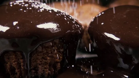 Slow motion two cupcakes in the glaze sprinkle with powdered sugar close up Stock Footage 96171943