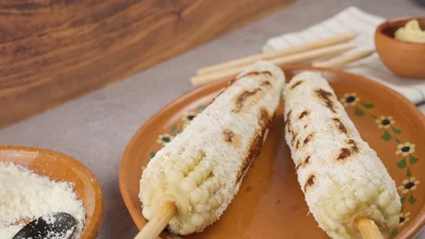 Slow motion of two elotes prepared with mayonnaise Cheese and red sauce Stock Footage 280316810