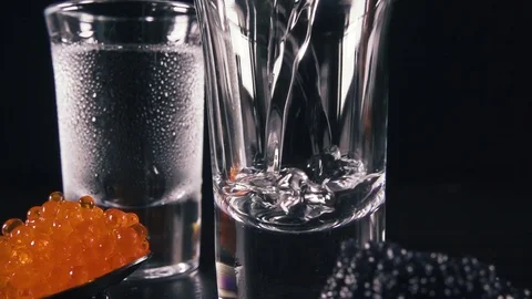 Slow motion two glasses of vodka next to the caviar Video stock 92430896