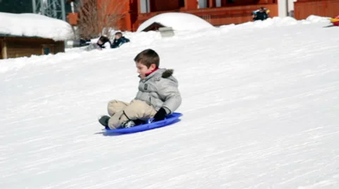 Slow motion two happy child that falls on snow with sledge Stock Footage 61876177
