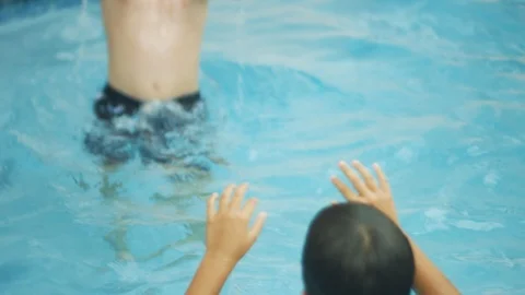 Slow motion of two kids playing with a ball inside a swimming pool Stock Footage 113036382
