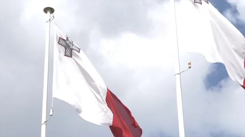 Slow motion of two Malta's waving flags under the clouds Stock Footage 90310737