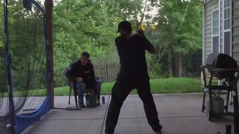 Slow motion of two men practicing hitting a baseball on a net Stock Footage 75116837