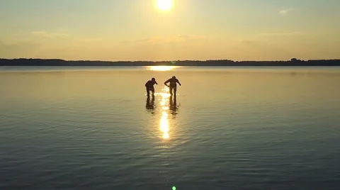 SLOW MOTION: Two men running along the water Stock Footage 53855019