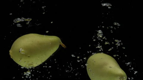 Slow motion two pear falling into transparent water on black background Stock Footage 196221749