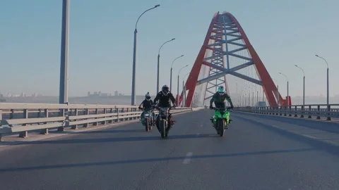 Slow motion. Two professional stunt bikers synchronously get on the rear wheels Stock Footage 105010837