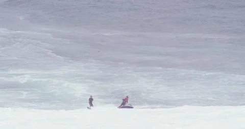 Slow motion two professional surfers surfing big waves together in raging ocean Stock Footage 156131500