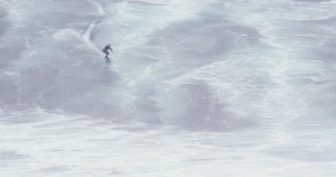 Slow motion of two professional surfers surfing big waves on board and jet ski Stock Footage 156131683
