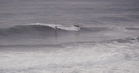 Slow motion of two professional surfers sitting on jet ski driving across ocean Stock Footage 160527315