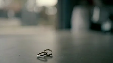 Slow motion of two wedding rings on the table Stock Footage 224297920
