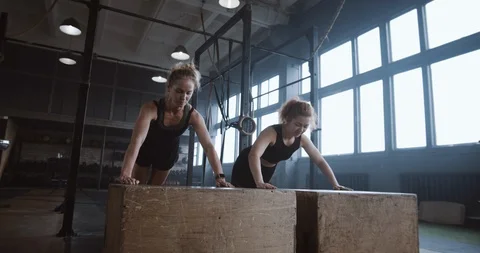 Slow motion two young beautiful female athletes working out, doing push-ups and Stock Footage 116881773