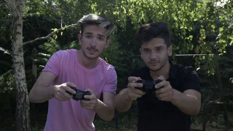 Slow motion of two young friends addicted to video gaming playing with contro Stock Footage 83113805