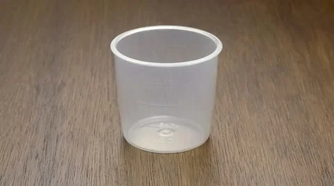 Slow motion of uncooked brown rice falling down into cup Stock Footage 63108358