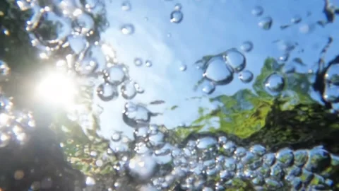 Slow motion underwater bubbles moving on the surface of a clear river Stock Footage 319879605