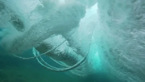 SLOW MOTION UNDERWATER: Powerful foaming barrel wave hitting camera on the way. Stock Footage 85365033