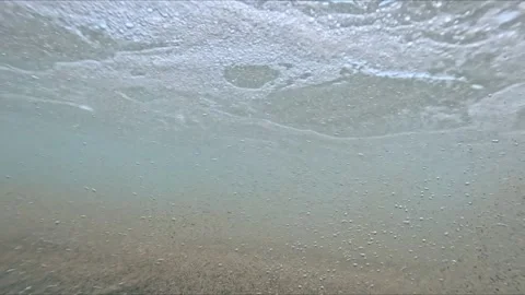 Slow motion underwater scene of sand clouds created by waves with visible p.. Stock Footage 317532425