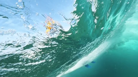 SLOW MOTION UNDERWATER: Unrecognizable fearless surfer riding big tube wave. Stock Footage
