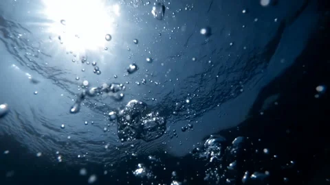Slow motion underwater video from the sea bottom on floating air bubbles in sun Stock Footage