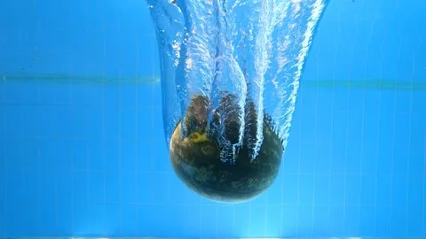 Slow motion underwater video of a watermelon falling and sinking into a pool Stock Footage 341369236