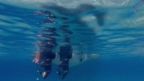 Slow motion underwater view of legs hanging from speedboat 스톡 동영상 279429285